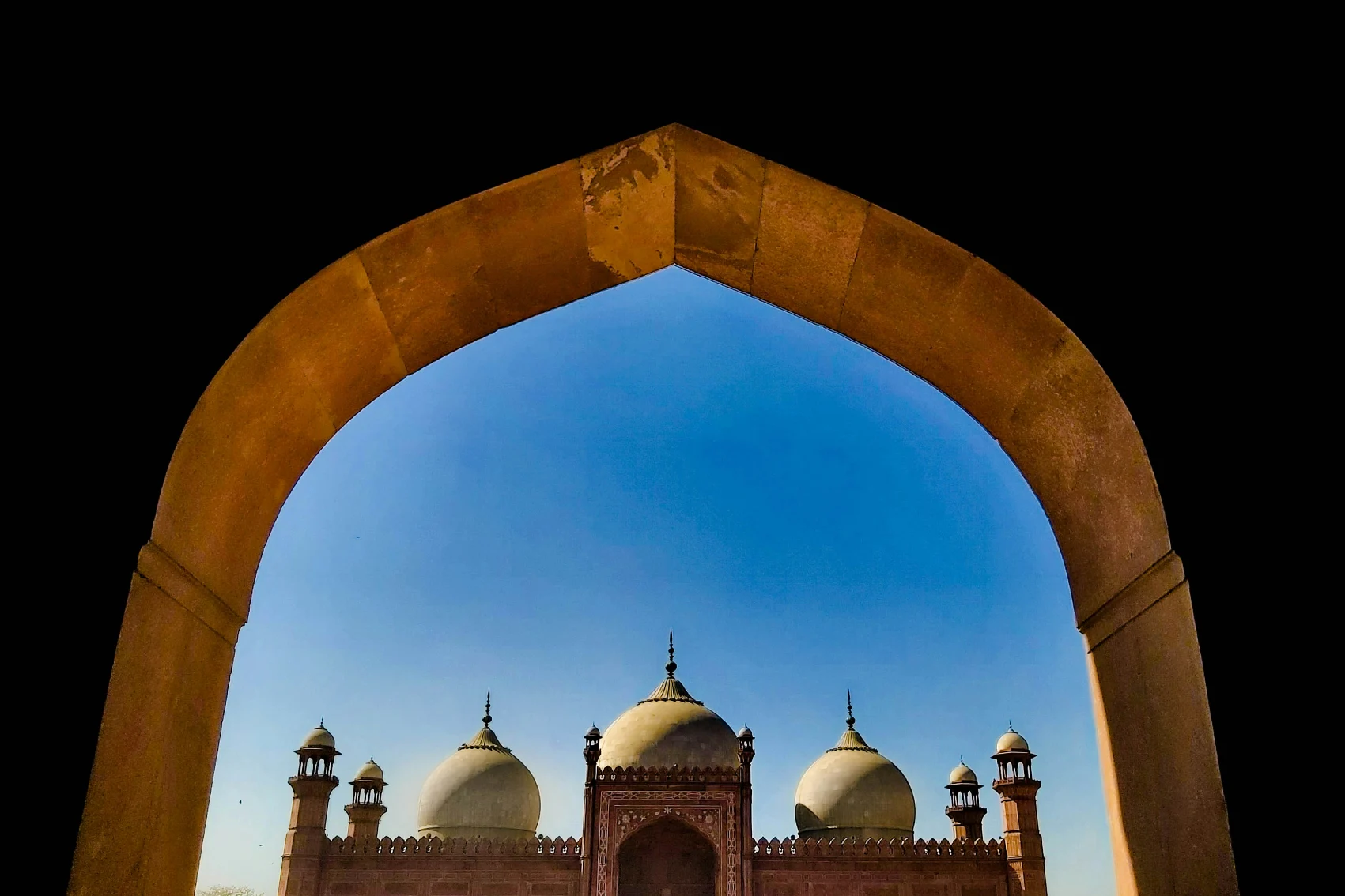 Incuriosendosi attraverso un'arcata alla splendida Moschea Badshahi di Lahore